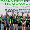 8 Ways to Save Money When Moving House in Perth - Advanced Perth Removals & Storage Group of removal company employees in black and green uniforms posing in front of a large 'Advanced Perth Removals' truck and branding.
