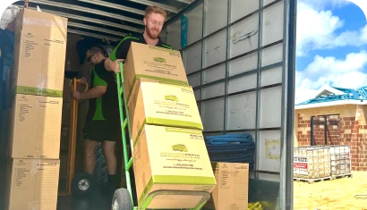 Removalist wheeling packed boxes off the truck on a hand trolley